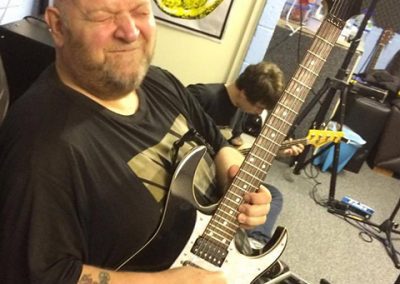 dave allott playing guitar making a face